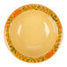 A yellow Venetian melamine bowl with orange and green flowers on it.