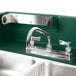 A green Cambro portable self-contained hand sink with two faucets.
