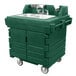 A green plastic Cambro CamKiosk portable self-contained hand sink cart with two sinks on wheels.