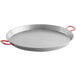 A close-up of a silver Vigor carbon steel paella pan with red handles.