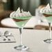 Two Acopa Select martini glasses filled with dessert on a table.