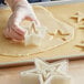 A person holding a Mercer Culinary star shaped cookie cutter.