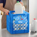 A person holding a white jug of milk in a blue Choice Super Crate.