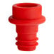 A close up of a red Acopa vacuum wine stopper with a hole in it.
