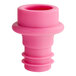 An Acopa pink plastic wine saver with a hole in it.
