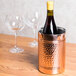 An American Metalcraft copper-plated stainless steel wine cooler on a table with a wine bottle in it.
