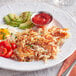 A plate of Honest Earth Shredded Hash Brown Potatoes with eggs and tomatoes.