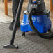 A person using a Lavex Pro wet/dry vacuum to clean a carpet.
