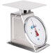 An Edlund heavy-duty portion scale with a white dial face on a stainless steel table.