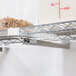 A Metro Super Erecta undershelf slide attached to a metal shelf with food containers on it.