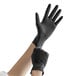 A person wearing black Showa nitrile gloves.