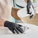 A person wearing Showa black biodegradable nitrile gloves cleaning a table.
