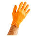 A hand wearing an orange Lavex Pro nitrile glove with a diamond texture.