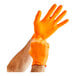 A person wearing Lavex Pro orange nitrile gloves.