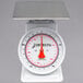 A white scale with a red dial and white base.