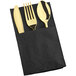 A black pocket fold napkin containing a gold fork, knife, and spoon.