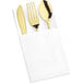 A white linen-feel napkin with Visions gold plastic cutlery including a fork.