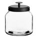 An Acopa Dusk clear glass jar with a black lid on a kitchen counter.