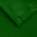 A close up of a green rectangular poly/cotton blend table cover with a hemmed edge.