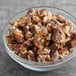 A bowl of SNICKERS® chocolate and nuts on a table.