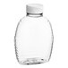 A clear plastic Classic Queenline honey bottle with a white cap.