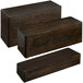 A group of three rectangular wooden display risers stacked on a table.