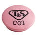 A pink round plastic button with black text reading "T & S CO2"
