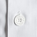 A close-up of a white button on a white Chef Revival short sleeve chef jacket.