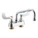 A T&S deck-mount faucet with two wrist action handles and a swing nozzle.