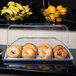 A white Cal-Mil bakery tray holding bagels and oranges on a counter.
