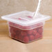 A translucent plastic container lid with a spoon notch on a container of cherry tomatoes.