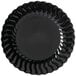 A black Fineline Flairware plastic plate with wavy edges.