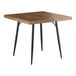 A Lancaster Table & Seating Mid-Century square wooden table with black legs.