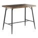 A brown Lancaster Table & Seating Mid-Century bar table with black metal legs.
