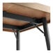 A wood table with Lancaster Table & Seating black metal legs.