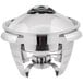 A Vollrath stainless steel round chafer with a lid on a table.