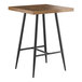 A Lancaster Table & Seating Mid-Century bar height butcher block table with black legs.