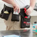 A man wearing a SC Johnson Professional TruShot 2.0 mobile dispensing belt with a white bottle of cleaning product in it.
