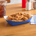 A blue paper tray with fried chicken on a table.