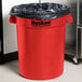 A red Continental Huskee 32 gallon round trash can with black liner.