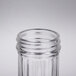 A close-up of a Tablecraft fluted glass salt and pepper shaker with a stainless steel lid.