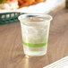 A World Centric clear plastic compostable cup with clear liquid and ice.