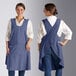 Two women wearing Acopa Ashville Ocean Linen smock bib aprons with pockets.