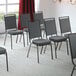 Lancaster Table & Seating Square Back Banquet Chairs with Gray Fabric and Black Frames in a room