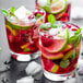A group of glasses of Smartfruit Wild Watermelon smoothies with fruit and a lime wedge.