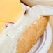 A close-up of a cheese sandwich with ham on a plate.