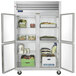 A Traulsen stainless steel reach-in refrigerator with two glass half doors full of food.