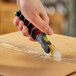 A hand using a CrewSafe X-traSafe utility knife to open a box