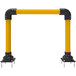 A yellow steel pipe with black horseshoe bollards on top.