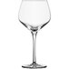 A close-up of a clear Schott Zwiesel Burgundy wine glass with a stem.